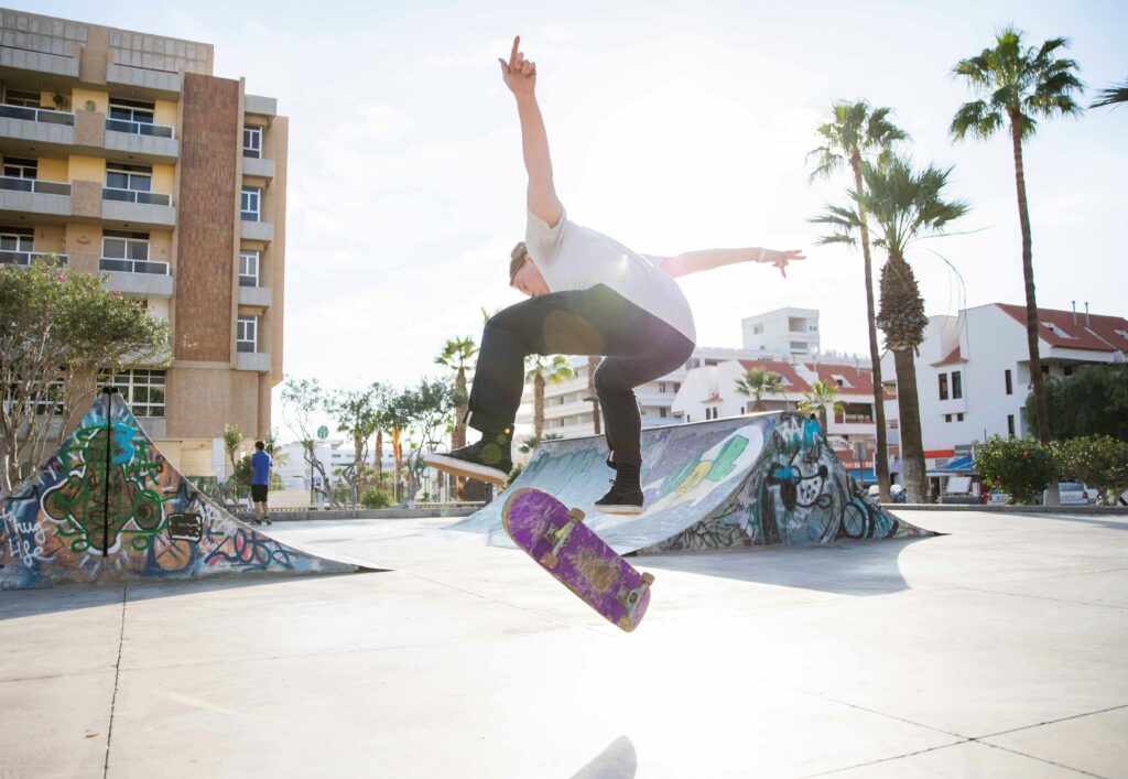 Teenage skateboarder performs a trick at Santa Cruz skatepark, sunny day.